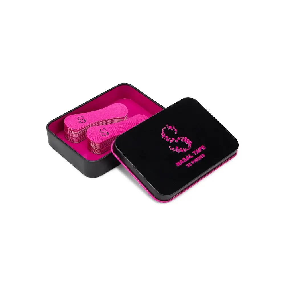 Pink nasal tape for better breathing in a stylish black and pink tin packaging.
